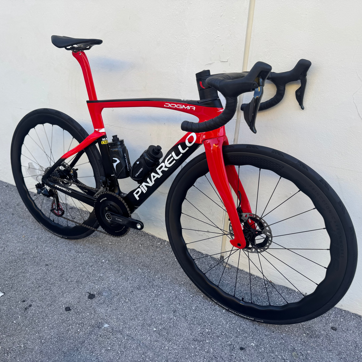 2022 Pinarello Dogma F B611 Black and Red- DuraAce Di2- Princeton Peak 4550 - 53 leaning against the wall at mack cycle